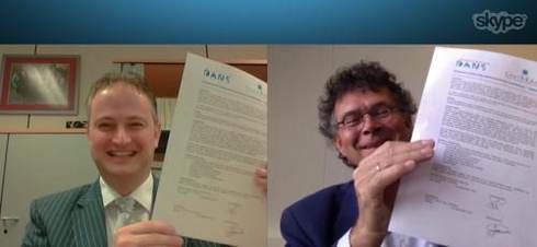 Directeuren Marcel Das (links, CentERdata) en Peter Doorn (rechts, DANS) tekenen de intentieovereenkomst voor hun samenwerking tijdens een Skype-sessie, om te onderstrepen dat je ook op afstand de krachten kunt bundelen.