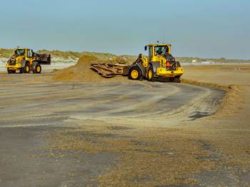 Het opruimen van aangespoelde mosdiertjes op het strand van Ameland. Foto: Jan Spoelstra