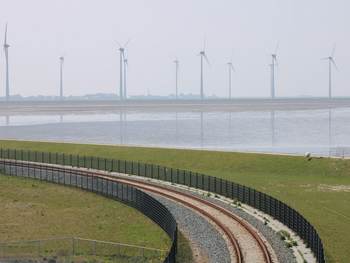 Spoorlijn en windmolens langs de waddendijk bij de Eemshaven