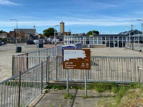 De haven van Terschelling met Unesco Werelderfgoedbord. Foto: Jamie Betz