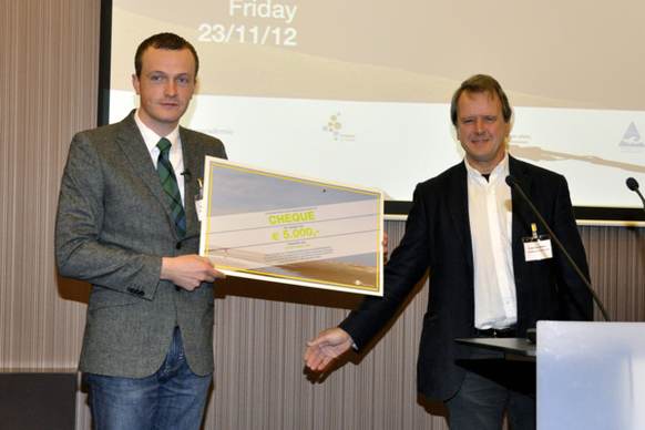 Hessel Speelman overhandigt Daniël Postma de cheque van 5000 Euro