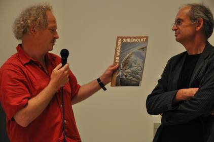 Fotograaf Peter Elenbaas en Theunis Piersma tijdens de overhandiging van het boek Wadden onbewolkt Bestuurslid Hessel Speelman tijdens de receptie