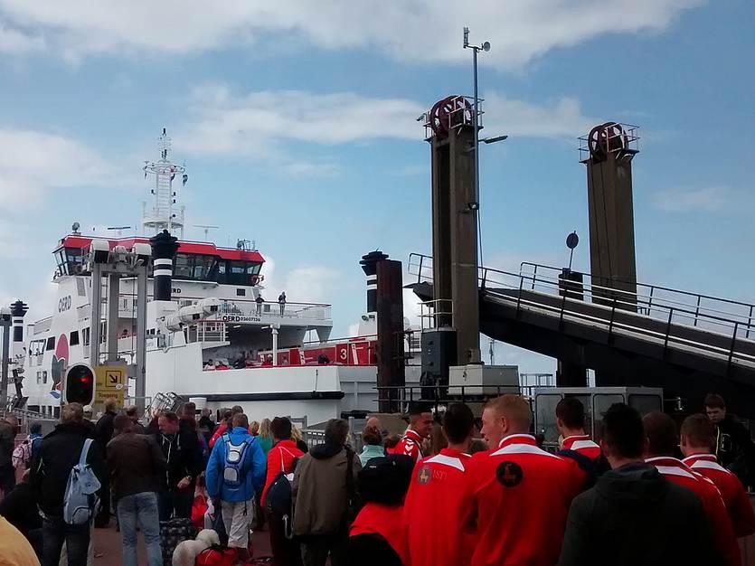 Toeristen wachten voor de veerboot naar Ameland