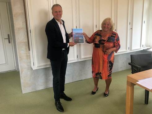 The mayor of Terschelling, Caroline van der Pol, receives the report from Pieter van Beukering