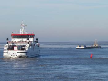 De veerboot passeert een baggerschip. Foto: TS