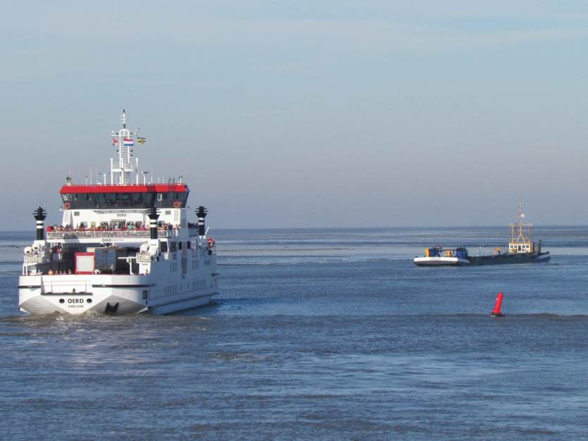 De veerboot passeert een baggerschip. Foto: TS