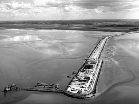 Op 25 mei 1969 werd de zee afgesloten en deze heet sindsdien Lauwersmeer. Op deze foto de losplaats aan het Vierhuizergat. Dijkvak naar de Groninger kust. Foto:      https://beeldbank.rws.nl, Rijkswaterstaat / Afdeling Multimedia Rijkswaterstaat 