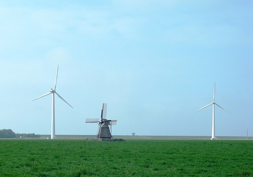 Bij de lezing van Jos Bazelmans op de Tijwisselaar conferentie had het publiek in Marrum uitzicht op de oude molen, geflankeerd door de windturbines. Foto: Aerden Plaats